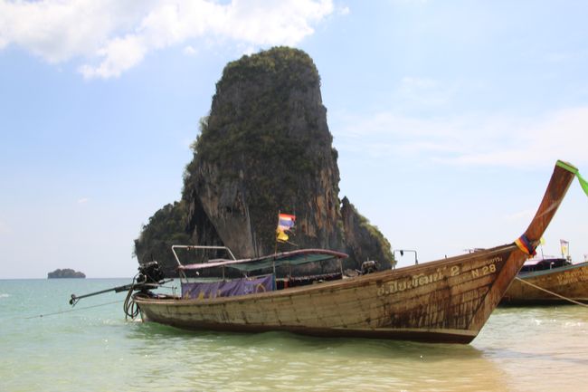 Longtailboot, im Hintergrund der Felsen vor dem Strand