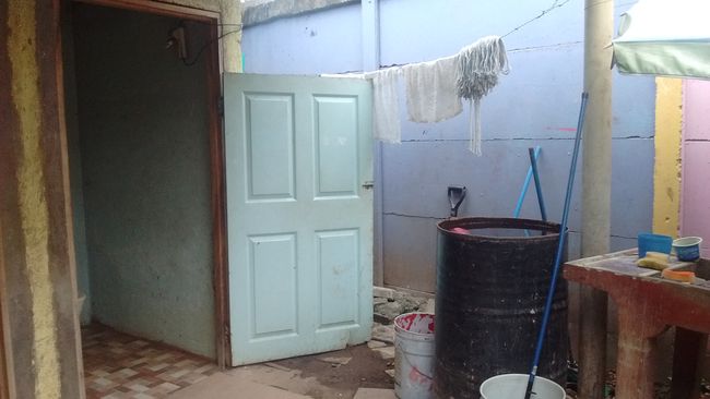 Rain barrel and door to the 'men's toilet'