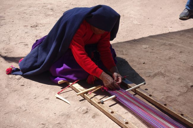 Die 80jährige Einheimische demonstriert die traditionelle Webkunst mit einem Alpaka Knochen als Hilfe...