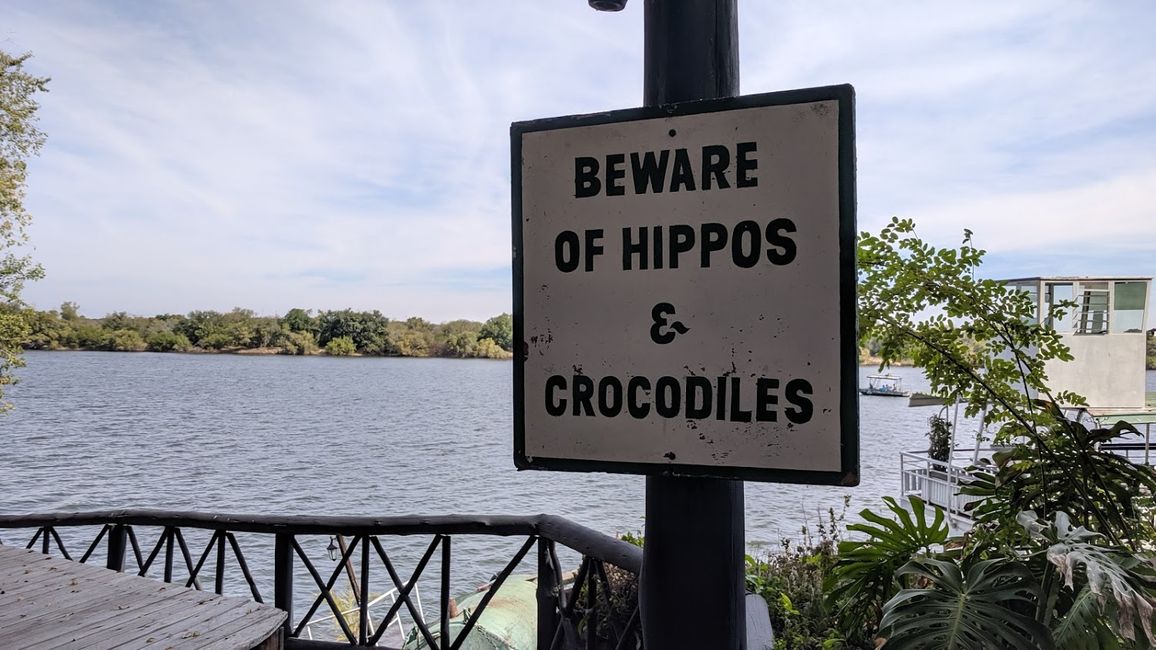 Warnschilder am Sambesi. Wir haben direkt am Hotel allerdings weder Hippos noch Kroos gesichtet.