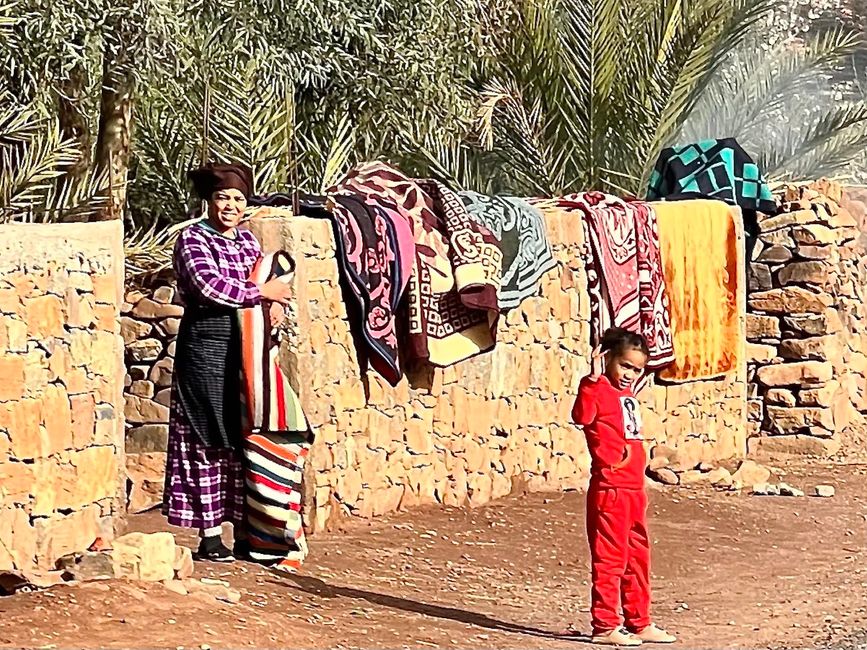 By the roadside: Mother and daughter with carpets. (Photo: Birgit)