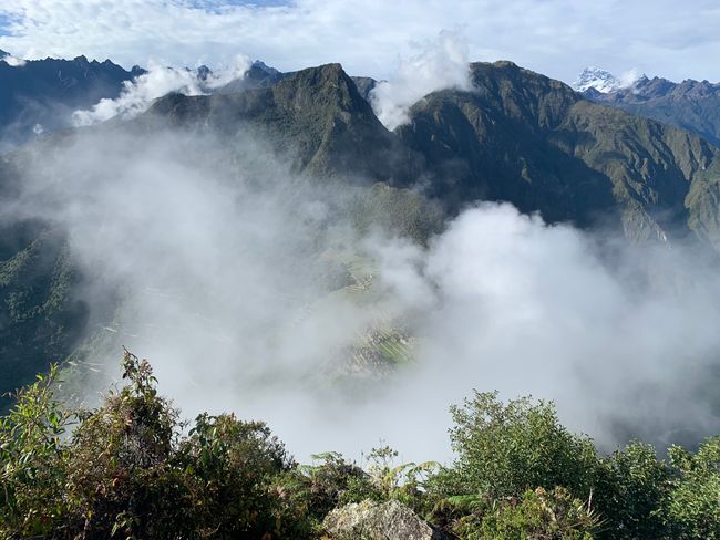 The first view from Waynapicchu of the Machu Picchu village, still covered in clouds