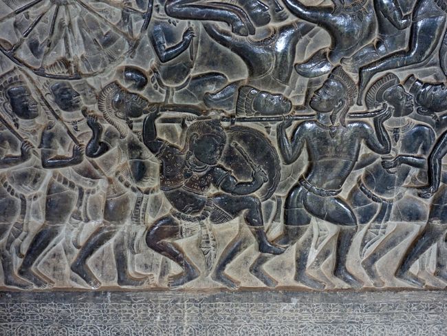 Angkor Wat in the smallest detail: a man strikes a gong
