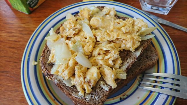 Scrambled eggs with onions on dark bread. Today a breakfast just like at home🙂 