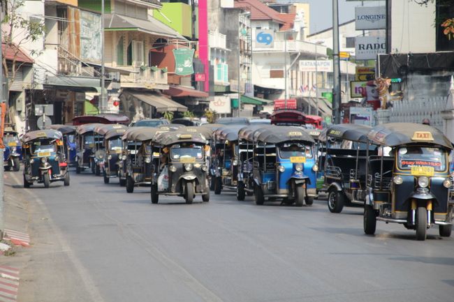 Tuk-tuk gathering in front of a very large and famous temple