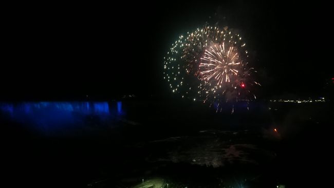 Fireworks over illuminated Niagara Falls