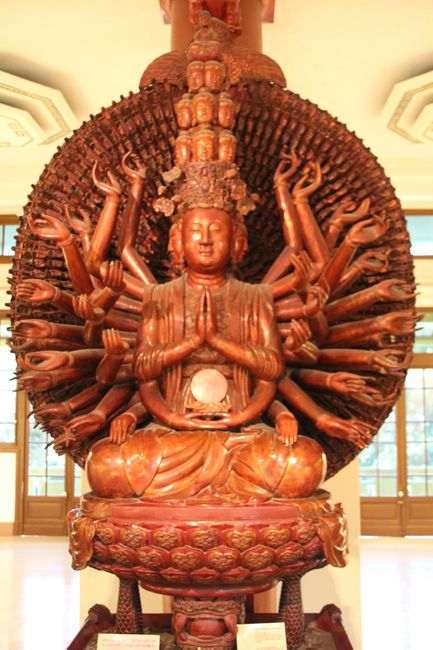 Hölzerner Buddha mit vielen Armen und Köpfen