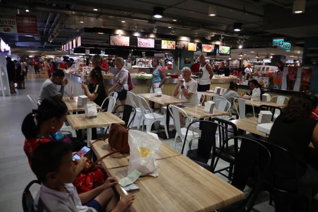 Many tables with people eating.