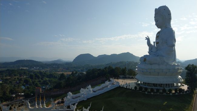 View of the entire Female Buddha. People are standing at the base for size comparison
