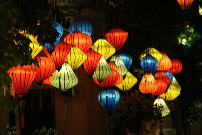 Lanterns hanging on the side of the street, brightly illuminated