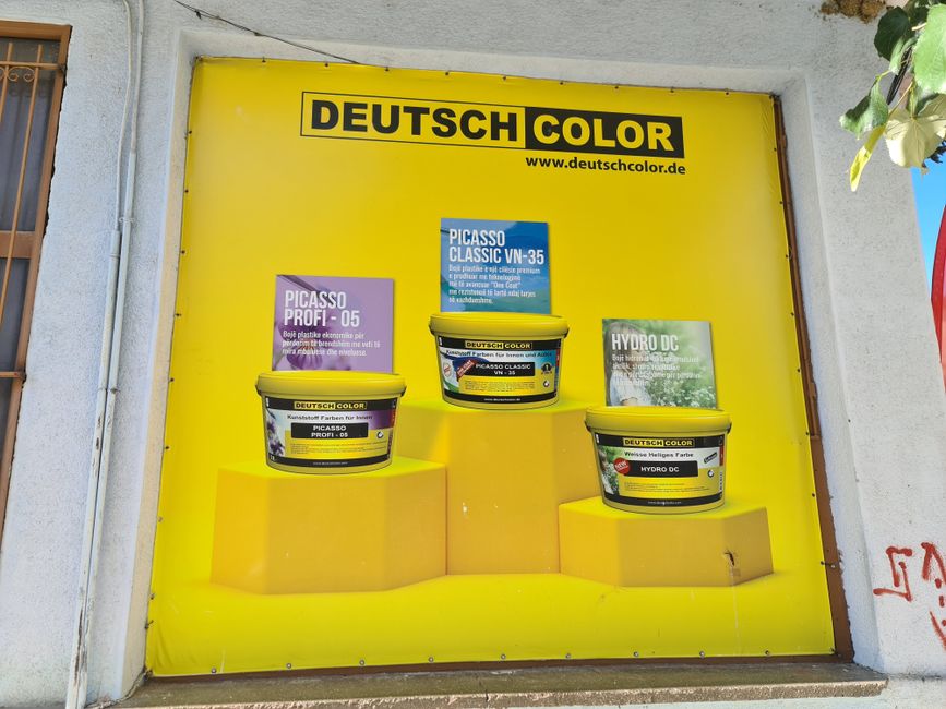 Deutsch Color Werbung an einen kleinen Handwerksladen in Erskë.