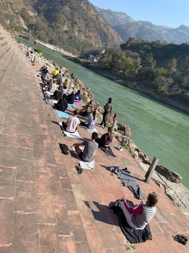 Alle Hochzeitsgäste beim Yoga am ruhig rauschenden Ganges.
