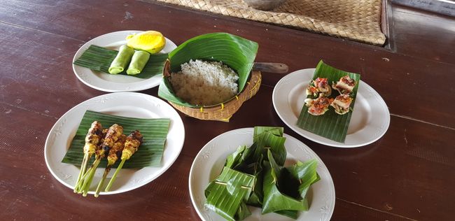 Chicken satay skewers, pancakes with caramelized coconut flakes, chicken in fresh banana leaves