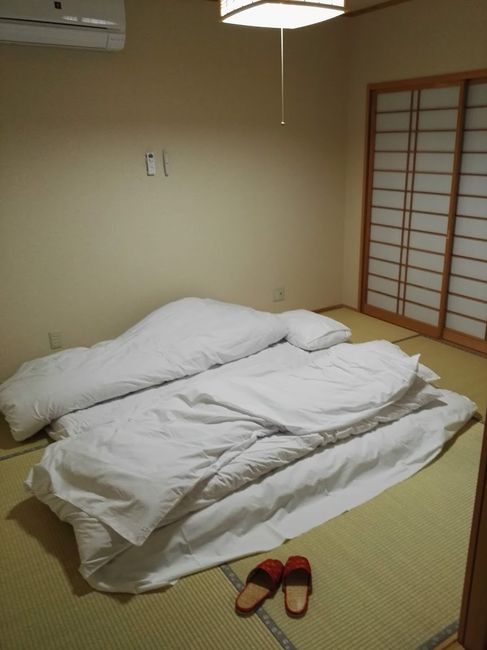 Ryokans bettfertig mit illegal platziertem Hausschuh im Vordergrund