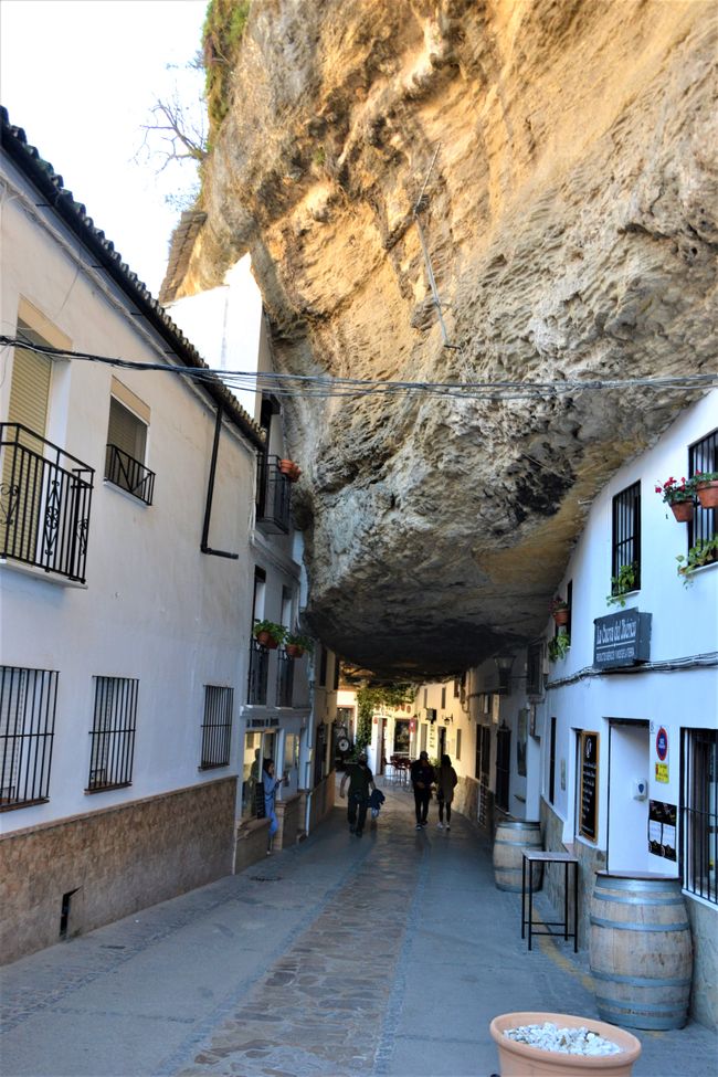überhängende Felsen, in die sogar die Häuser der gegenüberliegenden Seite gebaut wurden und die aus der Straße einen Tunnel machen, in Setenil de las Bodegas