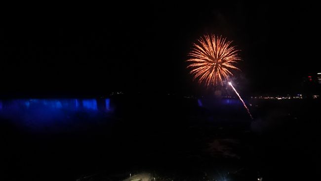 Fireworks over illuminated Niagara Falls