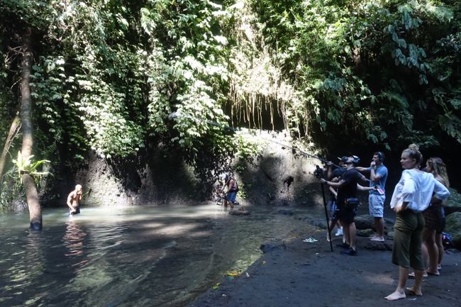 Film crew filming an action scene at the waterfall