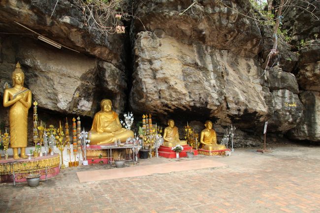 Phou Si: goldene Buddhas unter großen Steinen sitzend