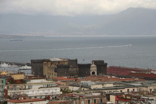 View of the port and Mount Vesuvius behind clouds