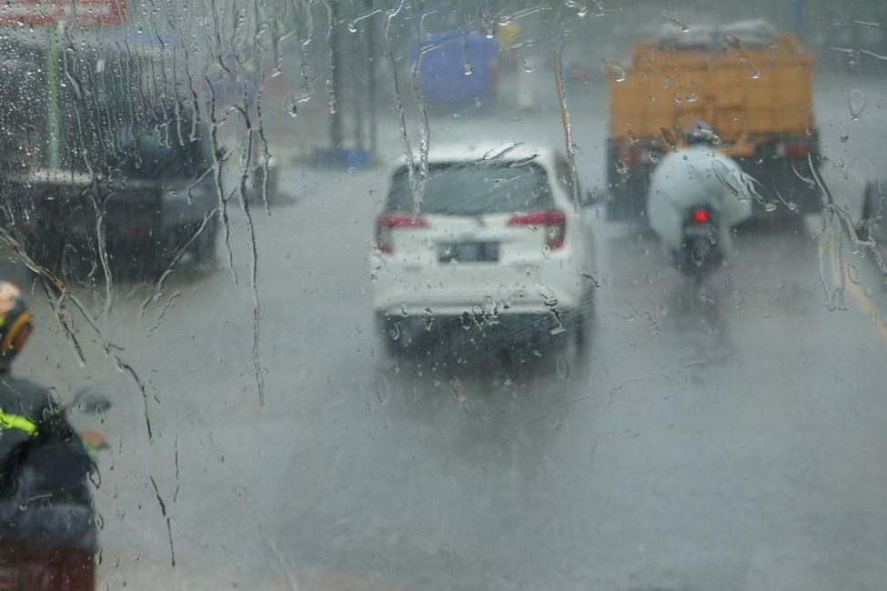 durch den Monsunregen sind die Straßen überflutet, die Mopedfahrer sind trotzdem unterwegs
