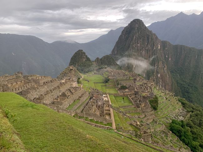 Der erste Blick auf das Inca-Dorf Machu Picchu am frühen Morgen Mit ein paar Wolken