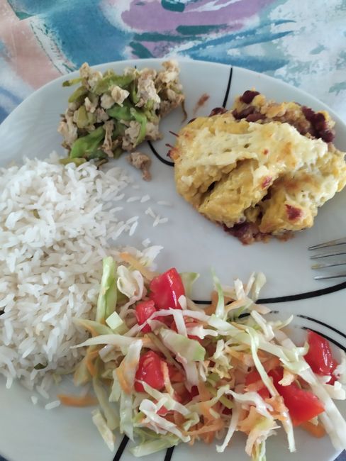 Reis (der wird teilweise 3x am Tag gegessen), Rührei mit Blumen, Krautsalat und ein Auflauf mit gestampfter Kochbanane und Bohnen
