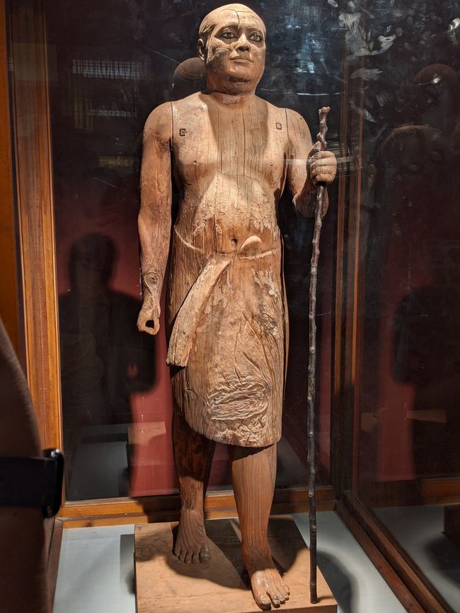 Holz(!)statue des Priesters Ka-aper. Er hat sich realistisch abbilden lassen, als ältere Mann inkl. Katarakt. 
