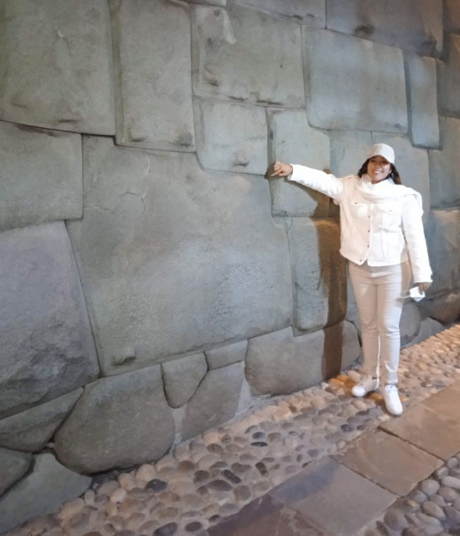 Frau zeigt auf den viel fotografierten zwölfkantigen Stein
