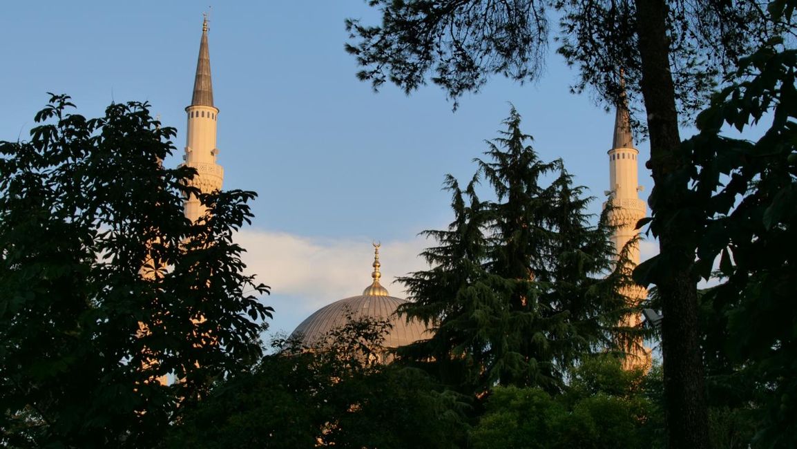 Namazgjah Moschee schaut hinter einem Park hervor