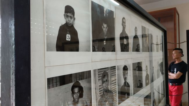 A photo wall of the victims, a child on top