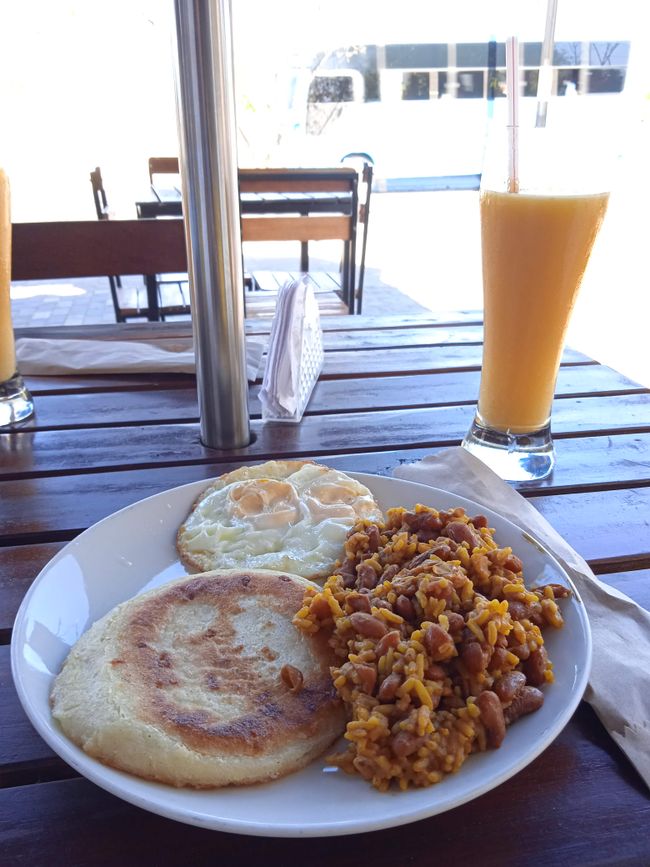 Frühstück, Arepa (Maisbrotpuffer), dazu Ei und Reis mit Bohnen
