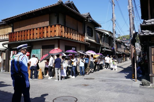 In the Gion district with Japanese people carrying umbrellas