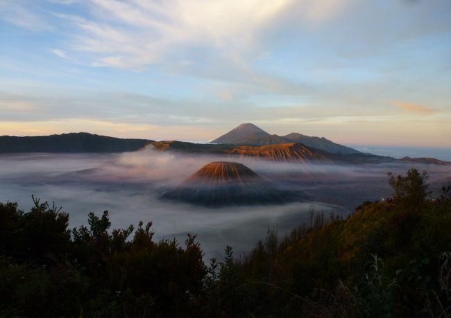 Bromo-Tengger-Semeru-Nationalpark  - Mitte links der Vulkan Bromo (wolkenverhangen), vorne rechts der Batok und im Hintergrund der höchste Berg Javas: Vulkan Semeru