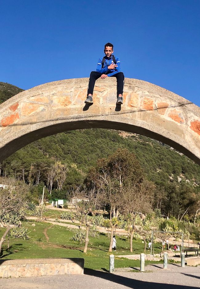 Cool: a Moroccan boy on a rock arch.