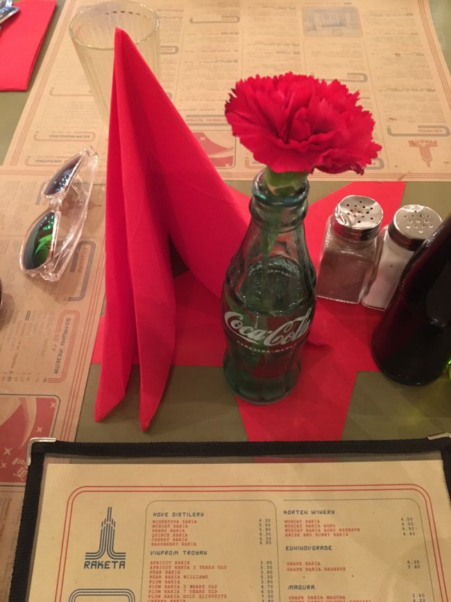Sociable interior and red carnations in Coca-Cola bottles: Raki bar Rakete