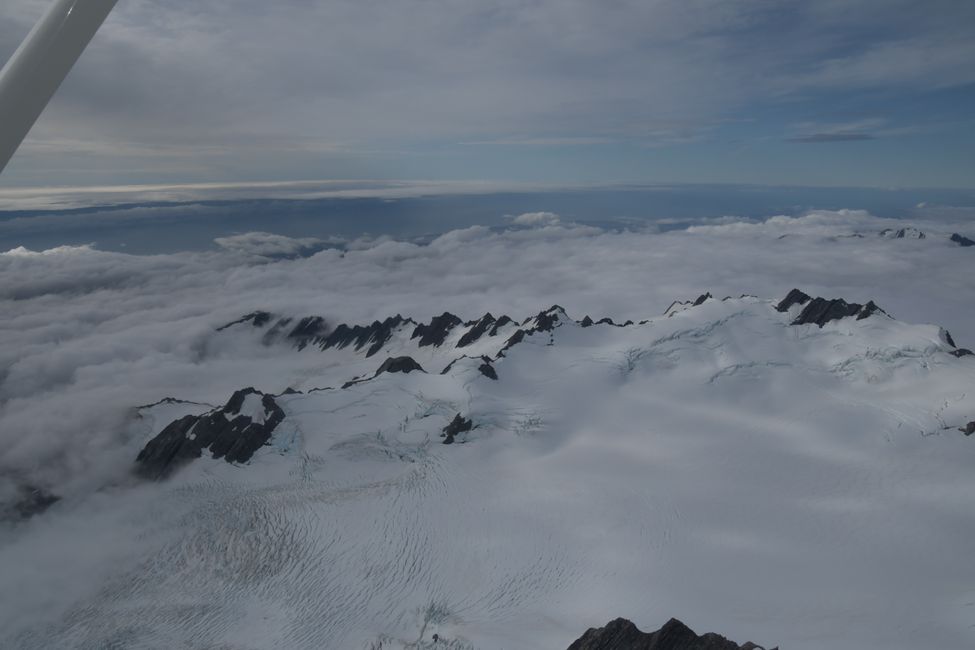 Flightseeing - Over the Southern Alps (the West Coast can be seen behind the cloud)
