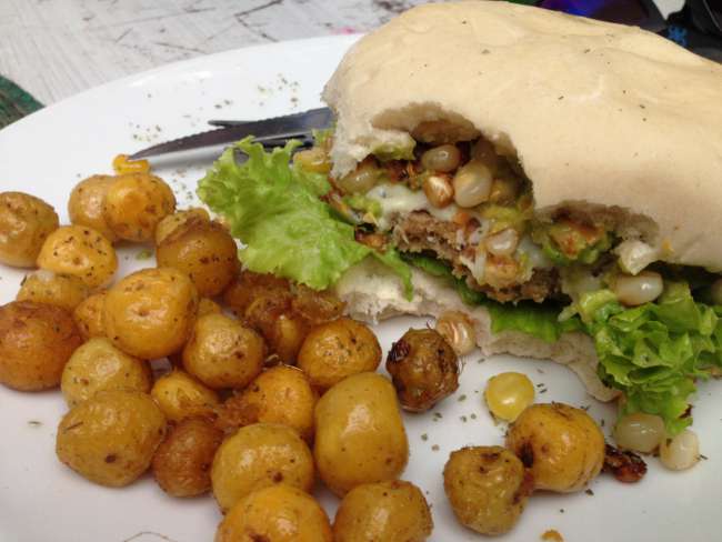 Vegetarian Burger with corn in it and little potatoes.