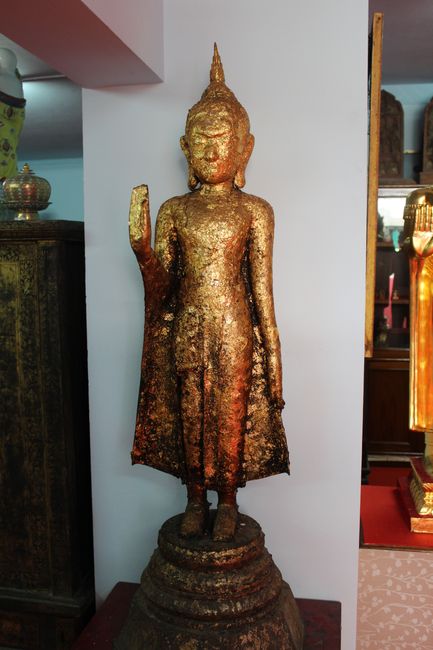 Wat Intharawihan: Stehender Buddha mit Blattgold beklebt und einer Hand nach vorne ausgestreckt