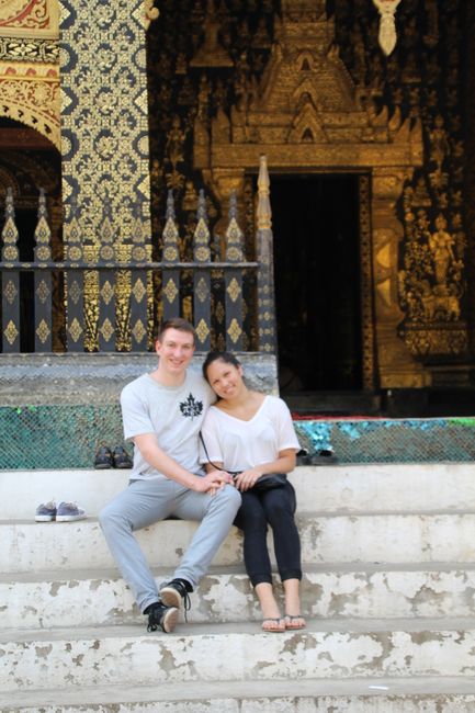 Us sitting on the stairs in front of Wat Xieng Thong