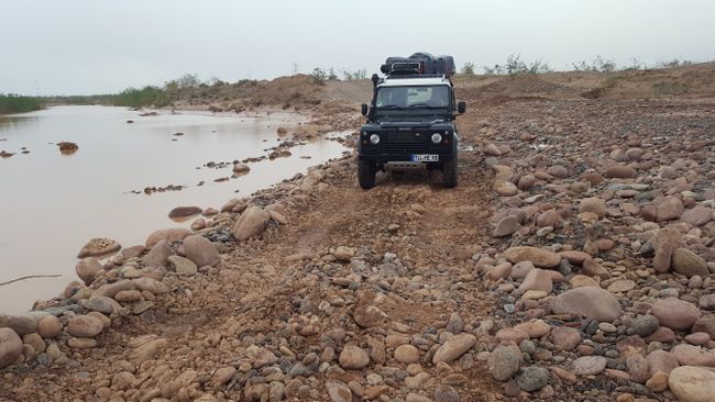 We drive on the autobahn to Agadir and then take a small road that crosses a dry riverbed. Unfortunately, there is now a small current, and initially, we don't know if we can pass through.