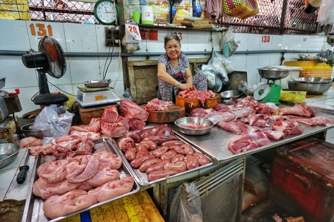 Die glücklichste Verkäuferin der Welt in ihrem Berg von Gammelfleisch