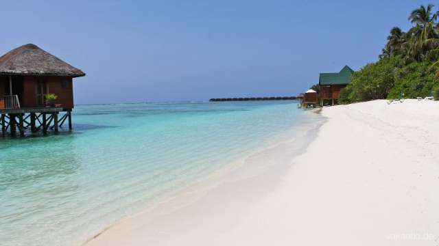 Dreamy white sandy beaches. Water bungalows in the background.