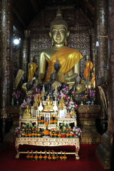 Wat Xieng Thong von innen: ein großer goldener Buddha mit vielen kleinen Buddhas davor