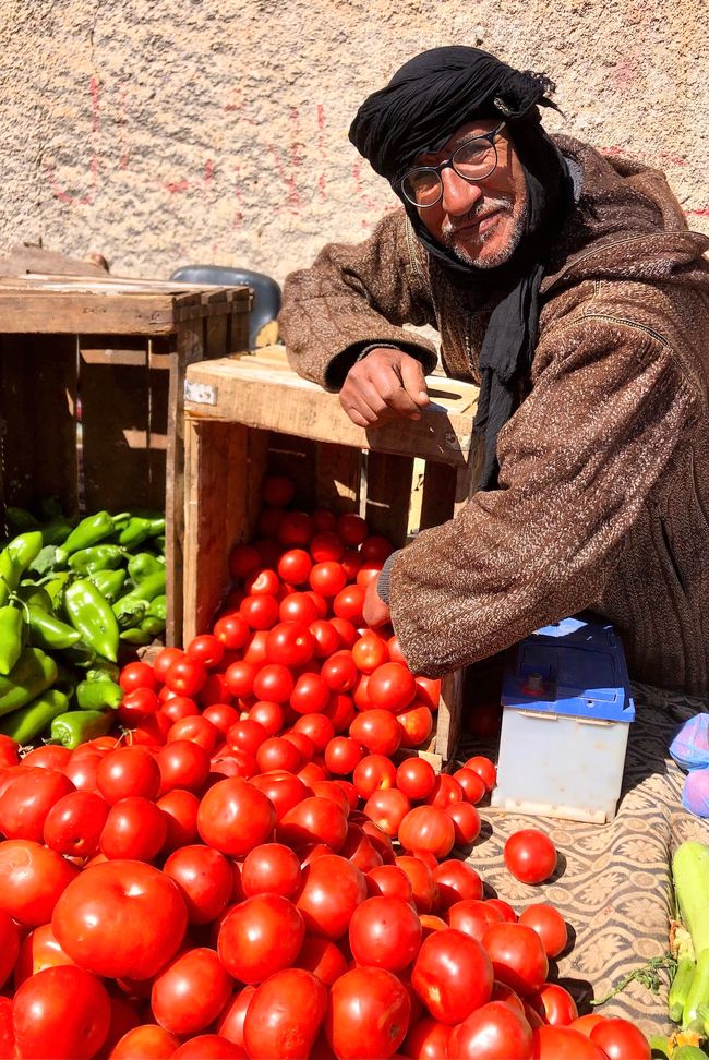 A friendly salesman shows us his tomatoes.