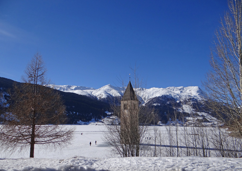 Church tower in Reschensee seen from the parking lot in Graun