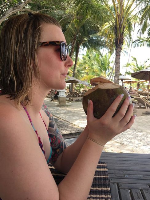 Christin trinkt aus einer frischen Kokosnuss