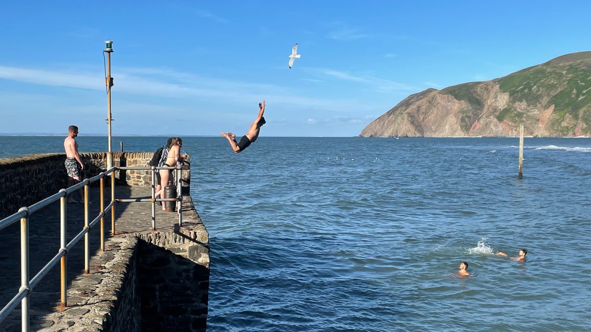 Teenagers jumping off the harbor wall