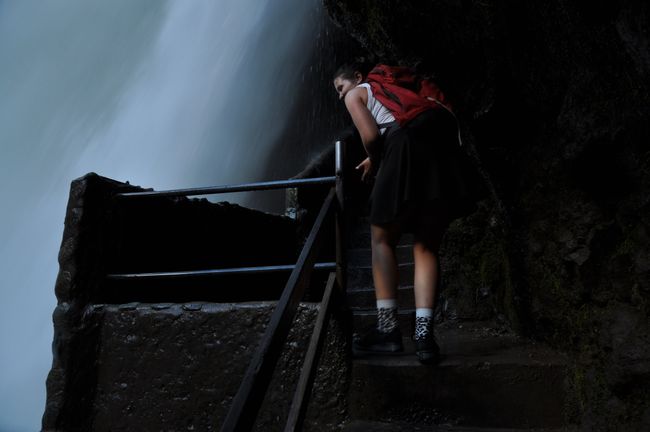 Auf rutschigen Treppen kann man bis hinter den imposanten Wasserfall krackseln ... 