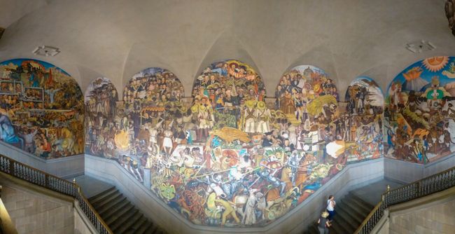 Mit den berühmten Murales von Diego Rivera. Farbenfroh wird hier die Geschichte Mexikos erzählt. 