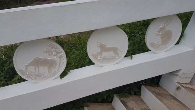 There are plate-like shapes on the railing with animals depicted.